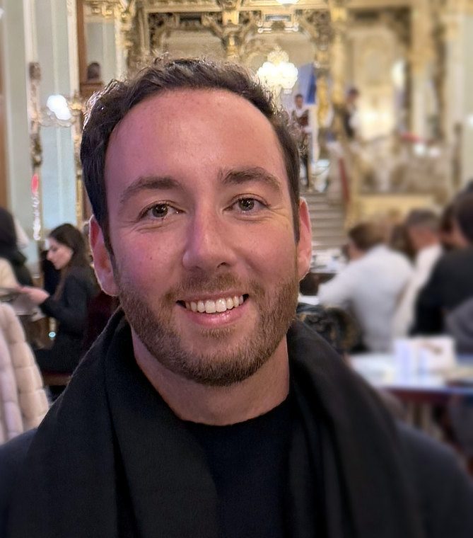 Alex Itkis at a historic café in Budapest
